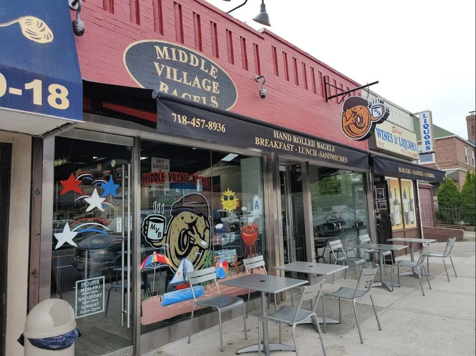 The red storefront and mascot at Middle Village Bagels